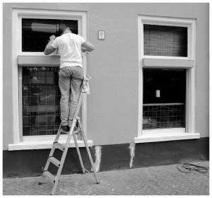 Man on a ladder looking in window